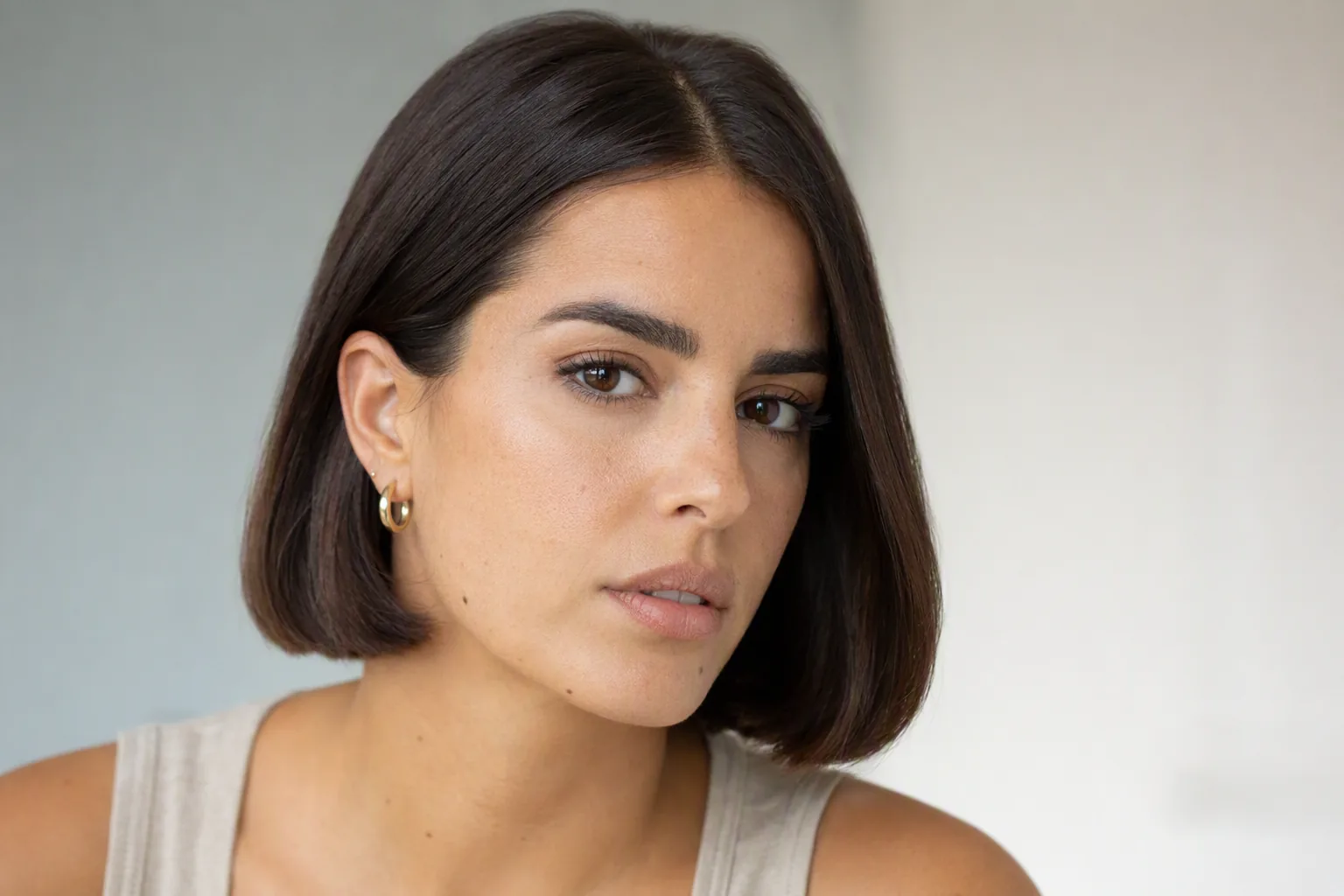 Retrato de mujer con bob castaño oscuro y camiseta beige, con luz suave