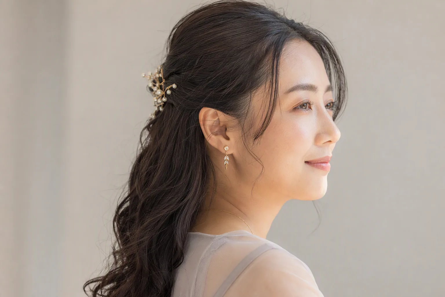 金色の髪飾りをつけたアップスタイルの女性を横から写した写真
